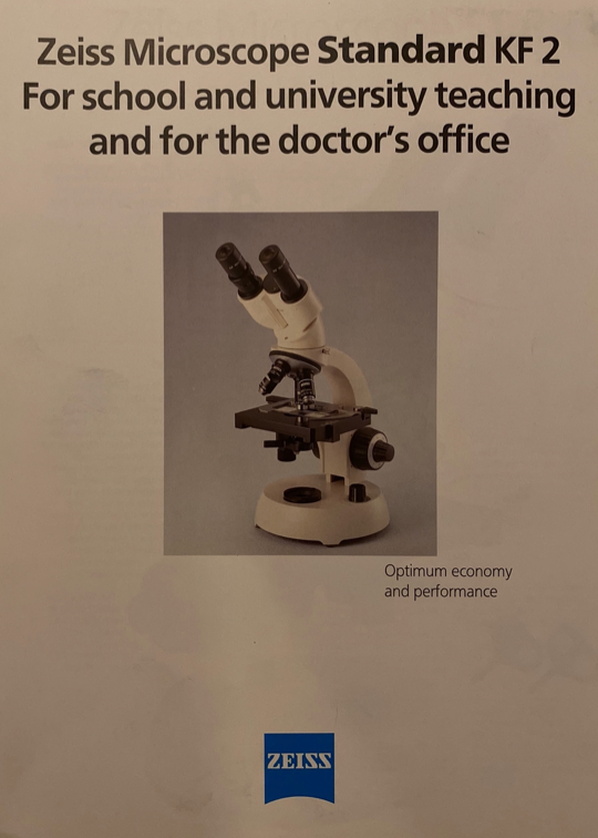 A white and black microscope
Description automatically generated